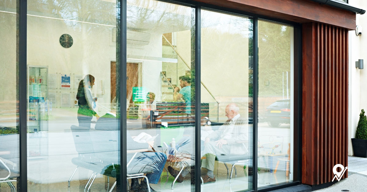 Employees in an office seen through glass windows
