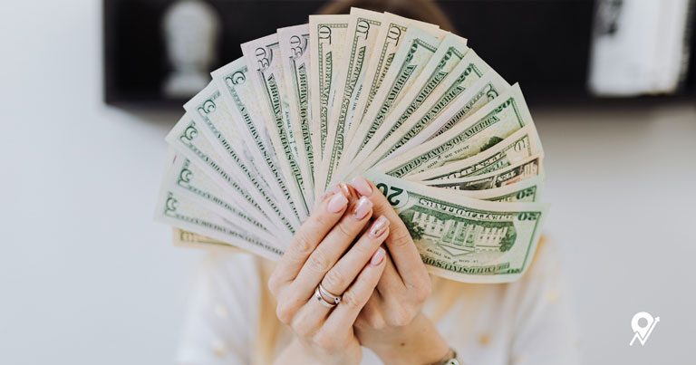 Person holding a fan of US currency