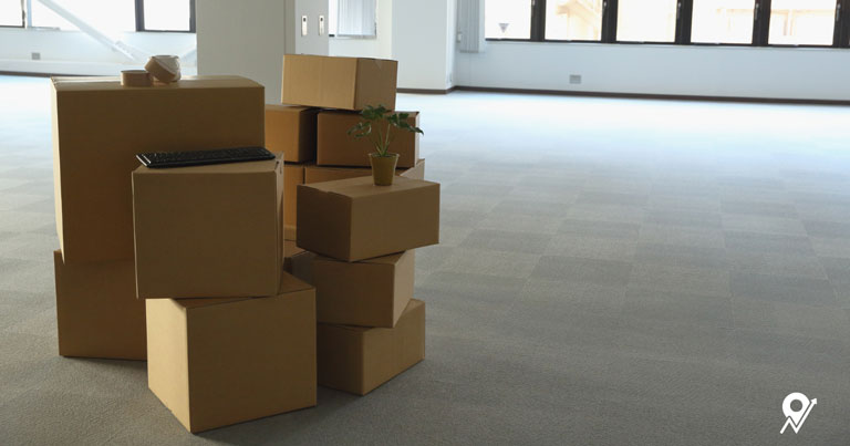 Moving boxes stacked in an empty office space